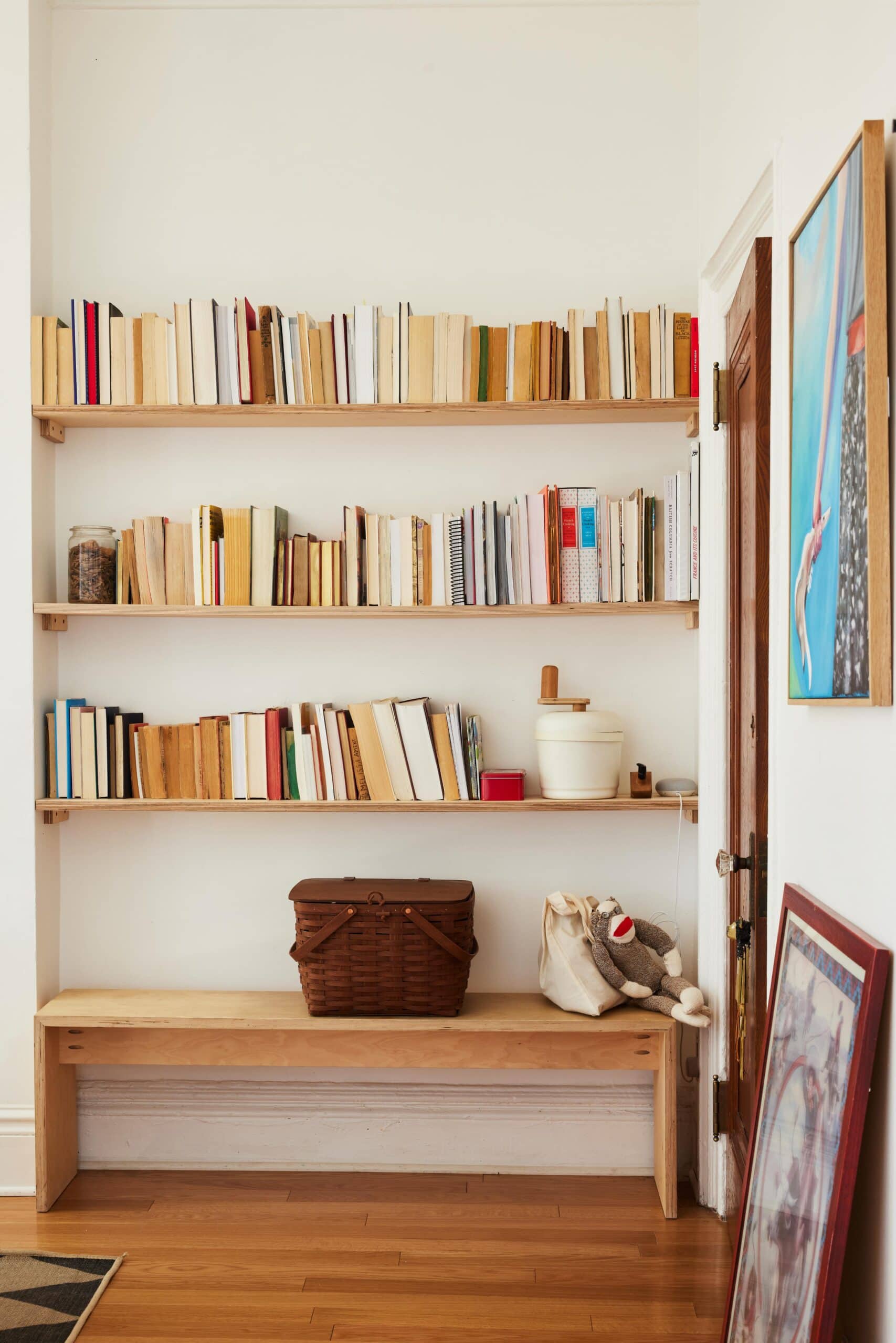 A shelf with books and a basket.